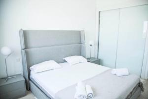 ein Schlafzimmer mit einem großen weißen Bett mit Spiegeln in der Unterkunft Confortable appart a la Marsa in La Marsa