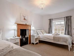 2 Bed in Slimbridge 90719 في كامبريدج: غرفة نوم بسريرين ومدفأة