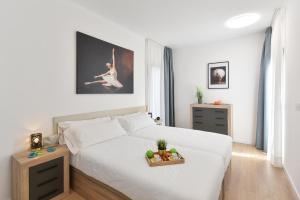 a bedroom with a white bed with a tray of fruit on it at Las Yucas 2 by VillaGranCanaria in Arguineguín