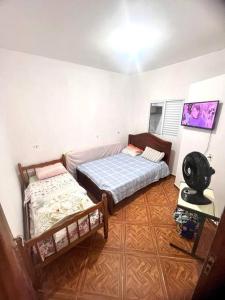 1 dormitorio con 2 camas en una habitación en Aconchego no Beco da Luz - Favela Santo Antônio, en Guarujá