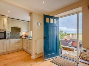 uma cozinha em plano aberto com uma porta azul e vista em 2 Bed in Caunton 91051 em Caunton