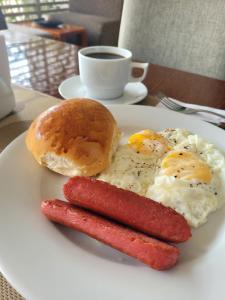 莫約班巴的住宿－Murano Hotel，鸡蛋和香肠盘子,百吉饼和咖啡