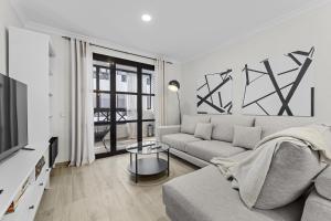 a living room with a couch and a tv at Casahost Guenia Beach Apartment in Arrecife