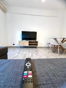 a living room with a tv and a remote control at Pearl of Sea in Lido di Ostia