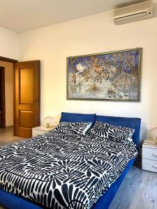 a bedroom with a bed with a painting on the wall at Pearl of Sea in Lido di Ostia
