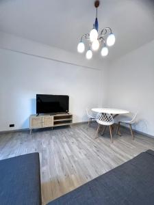 a living room with a tv and a table and chairs at Pearl of Sea in Lido di Ostia