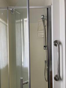 a shower stall with a glass door with a mirror at City Towers Apartments in Auckland