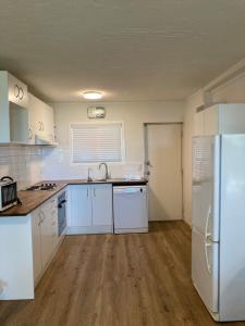 cocina con electrodomésticos blancos y nevera blanca en City Towers Apartments, en Auckland