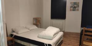 - un lit avec 2 oreillers dans l'établissement Appartements simples et fonctionnels, à Pamiers