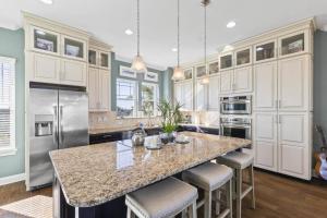 a kitchen with a large island with bar stools at Sunset Inlet Luxury Oasis | Flagler Beach in Flagler Beach