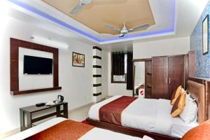 a hotel room with two beds and a ceiling fan at Hotel The Blue rose 500mtr Taj in Tājganj