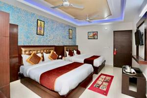 a hotel room with two beds and a television at Hotel The Blue rose 500mtr Taj in Tājganj