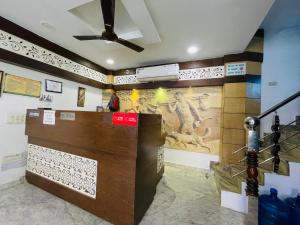 een kamer met een plafondventilator en schilderijen aan de muur bij Hotel The Blue rose 500mtr Taj in Tājganj