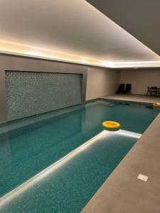 a pool with a yellow frisbee in the water at Apartment with Modern Amenities in Muscat