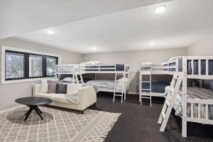 Habitación con literas, sofá y mesa. en Welcome Oakland Place-Luxury/sleeps 24/+bunk room en Hopkins