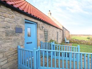 a blue door on a stone building with a fence at 3 Bed in Nr Bamburgh CN035 in Belford