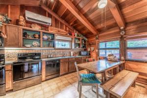 a kitchen with a table and a wooden ceiling at Deer Meadows: Adorable, Centrally Located Ruidoso Cabin with Private Hot Tub! in Ruidoso