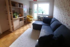 a living room with a blue couch and a table at Quiet and cozy 15 min bus to city center in Iru