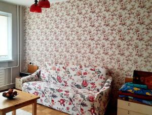 a living room with a couch and floral wallpaper at Quiet and cozy 15 min bus to city center in Iru