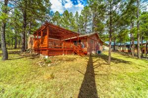 a log cabin in the woods with a large yard at Deer Meadows: Adorable, Centrally Located Ruidoso Cabin with Private Hot Tub! in Ruidoso
