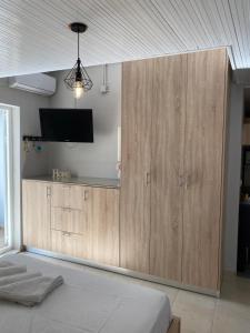 a bedroom with a large wooden cabinet with a tv on it at Home Apartments in Parga