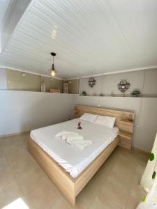 sypialnia z dużym łóżkiem z białą pościelą w obiekcie Home Apartments w mieście Parga