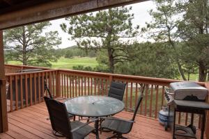 a patio table and chairs on a deck with a grill at Grisham's View Condo: Central Condo with a Golf Course View! in Ruidoso
