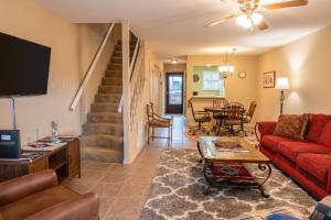 a living room with a red couch and a table at Grisham's View Condo: Central Condo with a Golf Course View! in Ruidoso