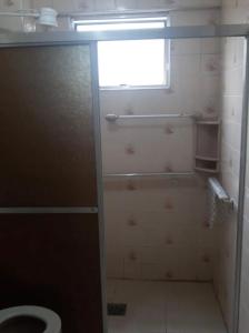 łazienka z prysznicem, toaletą i oknem w obiekcie Mourão 5 w mieście Praia Grande