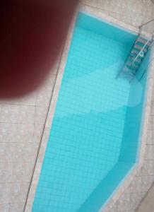 basen z niebieskimi płytkami na podłodze w obiekcie Mourão 5 w mieście Praia Grande