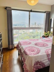 a bedroom with a bed and a large window at Habitaciones privadas con vista al parque castilla in Lima