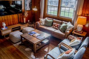 uma sala de estar com um sofá e uma mesa em Birch House: Cozy Cabin 5 min from Okemo em Ludlow