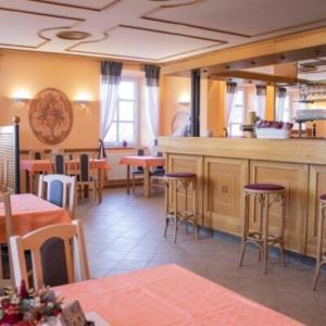 un restaurante con bar y algunas mesas y sillas en Hotel Zámeček Raspenava en Raspenava