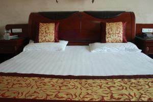 1 cama grande con 2 almohadas encima en Taizhou Taishan Business Hotel, en Taizhou