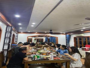 Un groupe de personnes assises à une table et mangeant de la nourriture dans l'établissement La Belle Vie Tam Coc Homestay, à Ninh Binh