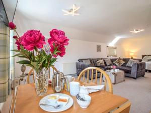 un jarrón de flores sobre una mesa en la sala de estar en 1 bed property in Filey 79278 en Wold Newton