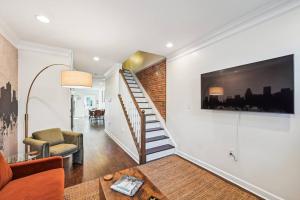 a living room with a staircase and a couch at Federal Hill Luxury + City Charm in Baltimore