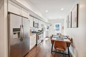 a kitchen with a table and a stainless steel refrigerator at Federal Hill Luxury + City Charm in Baltimore