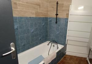 baño con bañera y pared de azulejos azules en T2 Haut de gamme - Gare Muret - TV & Wifi HD, en Muret