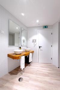 een badkamer met 2 wastafels op een aanrecht met een spiegel bij Boa Nova Hostel in Santa Cruz da Graciosa