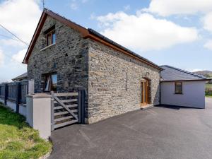 a stone house with a gate and a garage at 2 Bed in Lampeter 86507 in Cellan