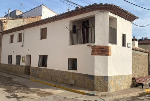 Casa Rural El Aljibe في San Agustín: مبنى أبيض أمامه مقعد