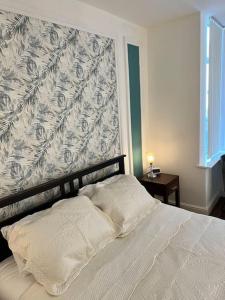 1 dormitorio con cama blanca y pared en One-Bedroom Flat with Parking and Garden, en Birmingham