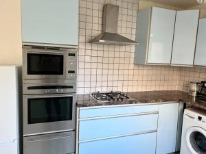 cocina con armarios blancos y fogones en One-Bedroom Flat with Parking and Garden, en Birmingham