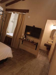 マリニリャにあるValerio Hotel Boutiqueのベッド、テレビ、テーブルが備わる客室です。