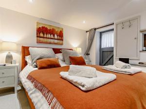 sypialnia z dużym łóżkiem i pomarańczowym kocem w obiekcie 1 Bed in Tavistock HGARD w mieście Marytavy
