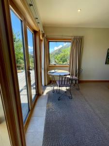 um quarto com uma mesa e cadeiras e uma grande janela em Parautane Lodge em Nelson