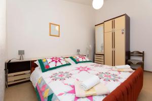 een slaapkamer met een groot bed en handdoeken bij Apartment Raos in Dugi Rat