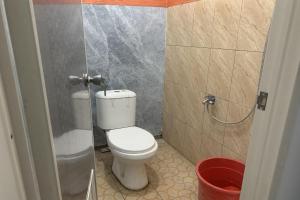 a small bathroom with a toilet in a stall at Mozza guest house in Klaten