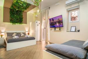 a bedroom with two beds and a green wall at Tropical Holiday House in Catania